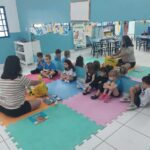 Turma sentada em roda no chão durante atividade socioemocional